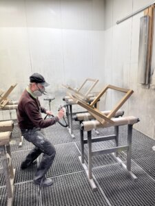 Handwerker behandeln nachhaltiges Holz mit ungiftigen Oberflächenbehandlungen, um die natürliche Maserung hervorzuheben. Dies ist Teil des Prozesses zur Herstellung von umweltfreundlichen Holzmöbeln, bei denen der Schwerpunkt auf Haltbarkeit und Ästhetik liegt.