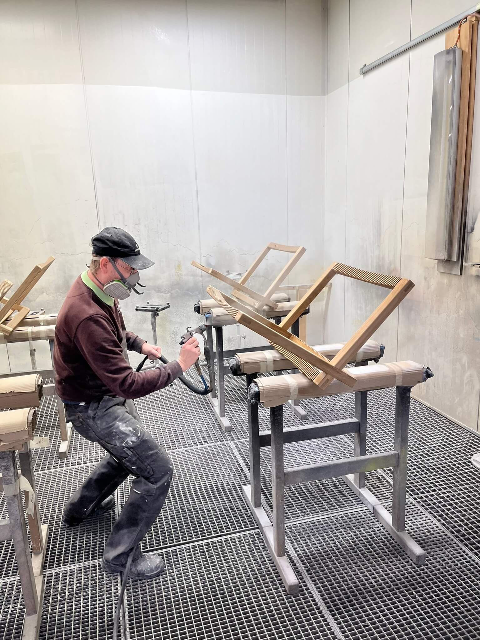 Handwerker behandeln nachhaltiges Holz mit ungiftigen Oberflächenbehandlungen, um die natürliche Maserung hervorzuheben. Dies ist Teil des Prozesses zur Herstellung von umweltfreundlichen Holzmöbeln, bei denen der Schwerpunkt auf Haltbarkeit und Ästhetik liegt.